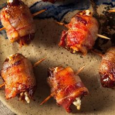 bacon wrapped in toothpicks on a plate with other food items around it and garnished with toothpicks