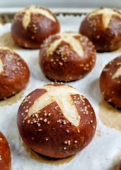 freshly baked hot cross buns sitting on top of a baking sheet, ready to go into the oven