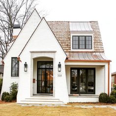 a white house with two windows and a metal roof is featured in the instagram post