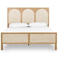 an image of a bed with white linens and wood headboard on the side