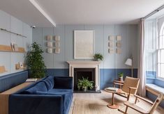 a living room filled with furniture and a fire place next to a window covered in potted plants