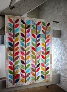 a multicolored quilt hanging on the wall