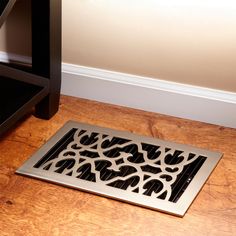 a black floor mat sitting on top of a hard wood floor next to a chair