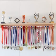 several medals are hanging on a shelf with ribbons