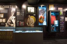 an exhibit case with various items on display in the center, including guitars and other memorabilia