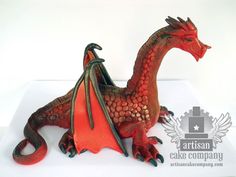 a red dragon figurine sitting on top of a white surface