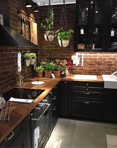 a kitchen with black cabinets and wooden counter tops