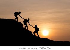 three people helping each other to climb up a hill with the sun setting in the background