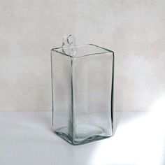 a square glass vase sitting on top of a table