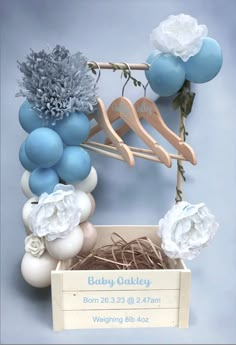 a blue and white baby's first birthday party with balloons, flowers and clothes pins