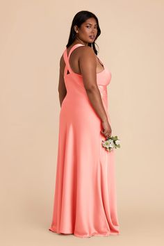 a woman in an orange dress holding a flower