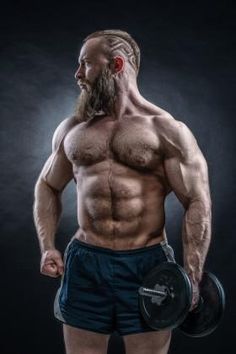 a man with a beard and no shirt holding a barbell