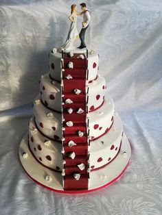 a wedding cake that is shaped like a tower with hearts on the top and bottom