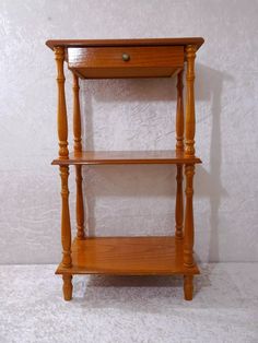 a small wooden shelf with two shelves on each side and one drawer at the top