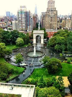 an aerial view of a park and fountain in the middle of a city with tall buildings