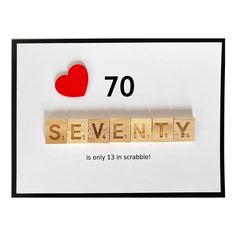 a scrabbled wooden block with the word seventy on it and a red heart