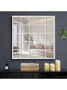 a living room with a large mirror on the wall and candles in front of it