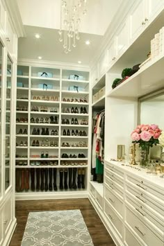 an image of a walk in closet with white cabinets and drawers on the bottom shelf