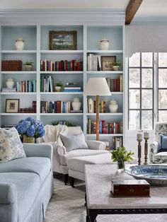 a living room filled with furniture and bookshelves covered in blue bookcases