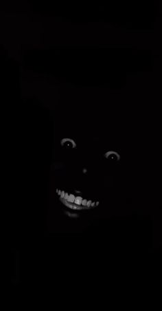 a black and white photo of a person's face in the dark