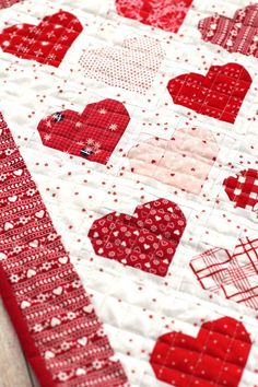 a red and white quilt with hearts on it