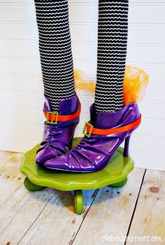 the legs of a person wearing colorful shoes on top of a skateboard