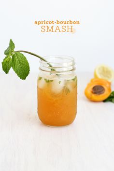 a glass jar filled with liquid next to sliced oranges and mint on a table