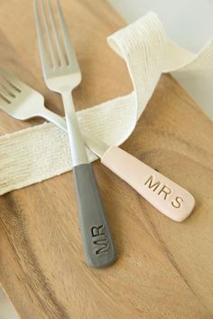 two forks, one with the word mr and mrs on it next to a napkin