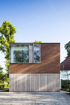 a brick house with two windows and a large driveway