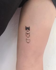 a small cat tattoo on the right arm and leg, with two cats behind it