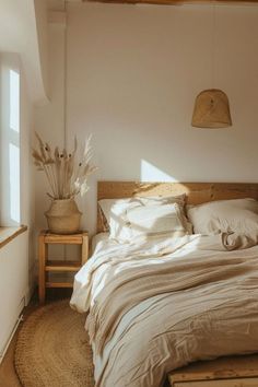 a bed sitting in a bedroom next to a window with sun shining through the windows