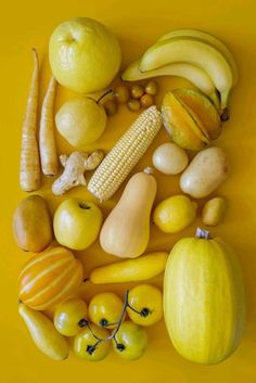 an arrangement of fruits and vegetables on a yellow background