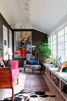 a living room filled with lots of furniture and plants on top of windowsills