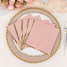 pink napkins and gold place mats on a plate