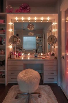 a white vanity with lights on it and a stool in front of the mirror that is lit up