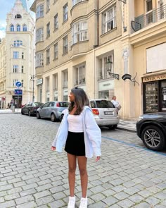 a woman standing on the street talking on her cell phone