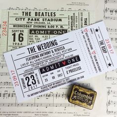 the wedding ticket is laying on top of sheet music