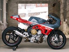 a red and black motorcycle parked in a garage