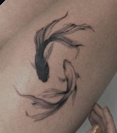 a woman's thigh with a black and white koi fish tattoo on it