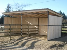 a small wooden shed sitting on top of a dirt field