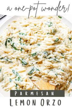 pasta with spinach and parmesan cheese in a white bowl next to a wooden spoon