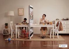 two people sitting at a table in front of a mirror and another person laying on the floor