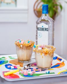 Two cereal milk cocktails garnished with Lucky Charms Marshmallows sit next to a bottle of Iceberg Vodka Cereal Cocktails, Cocktails Easy, Lucky Charms Marshmallows, Coffee Liqueur, Cocktail Garnish, Milk Coffee