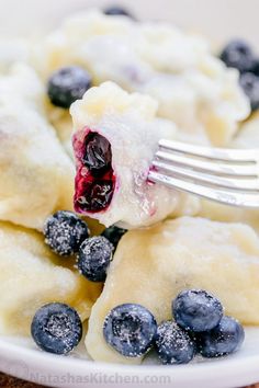 blueberries and dumplings are being eaten with a fork