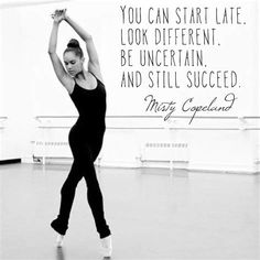 a woman in a black leotard is dancing with a quote on the wall behind her