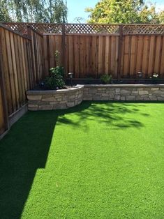 a backyard with artificial grass and wooden fence