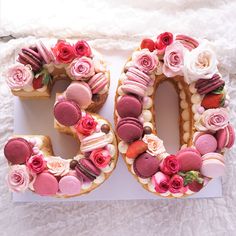 the number 50 is made out of cookies and decorated with pink frosting, roses, and macaroons