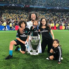 a group of people posing for a photo with a soccer trophy