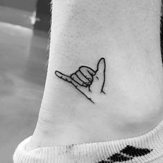 a black and white photo of a small hand tattoo on the ankle that reads i love you