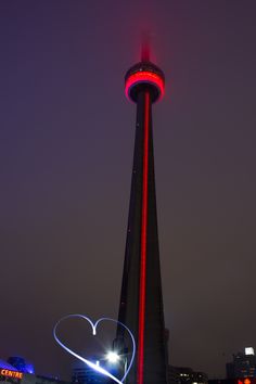 a tall tower with a heart shaped light on it's side